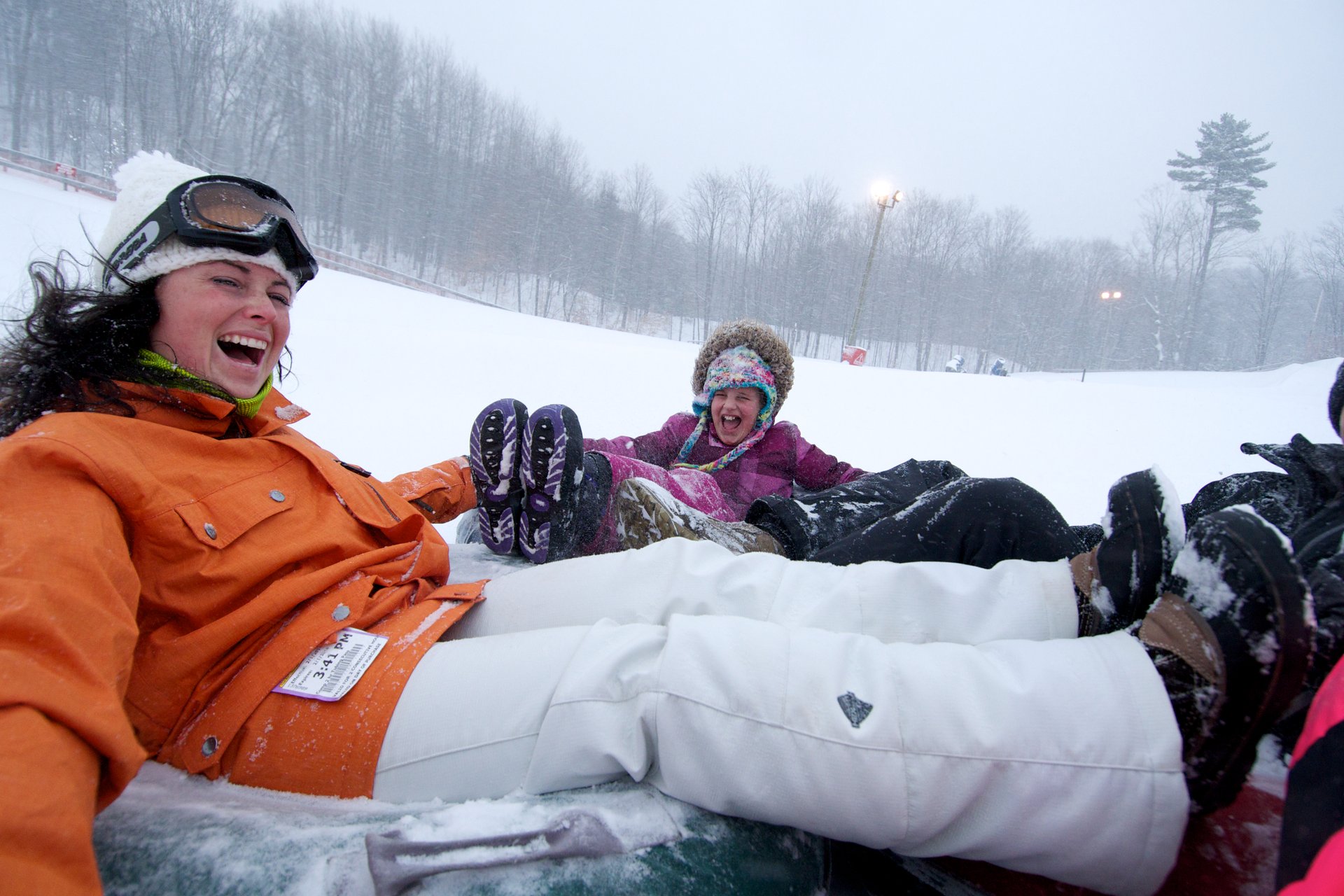 Horseshoe Resort snow tubing group with people laughing as they go down the hill